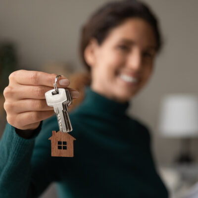 Close,Up,Focus,On,Keys,,Smiling,Woman,Realtor,Selling,Apartment,